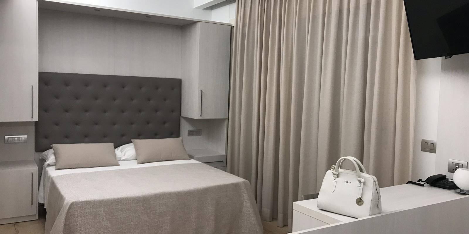 Camera moderna con letto matrimoniale e TV.