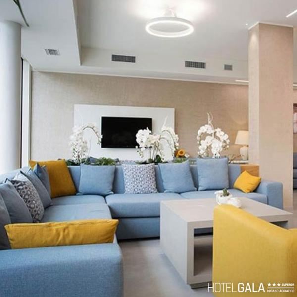 Soggiorno moderno con divano blu e giallo, decorazioni floreali.