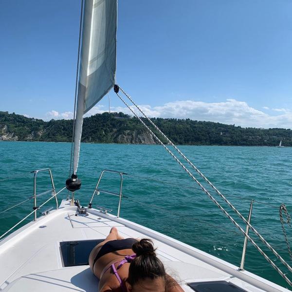 Persona rilassata su una barca a vela in mare.
